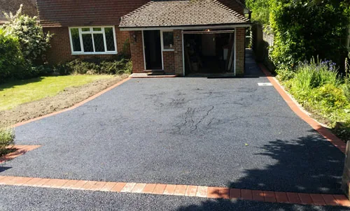 Tarmac driveway with contrasting block borders outside a house