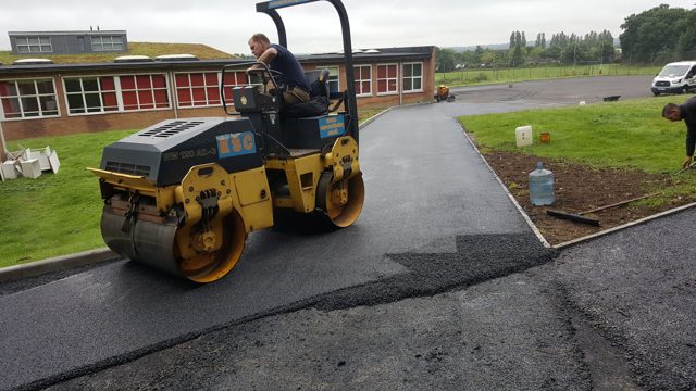 Bomag tandem vibrating roller compacting the new asphalt surface