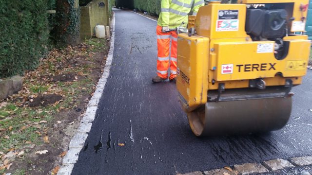 Compacting asphalt surfacing on a private lane