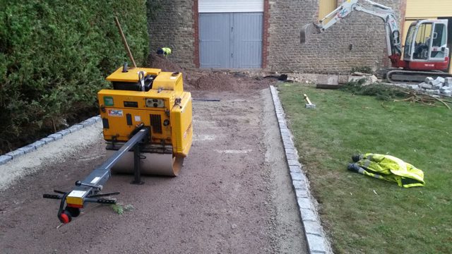 Pedestrian roller compacting a narrow prepared base
