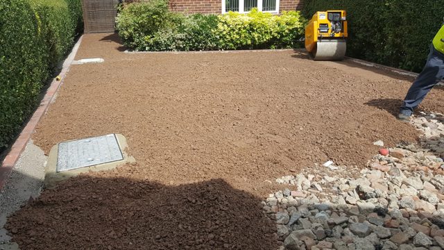 Compacted driveway base with a service cover