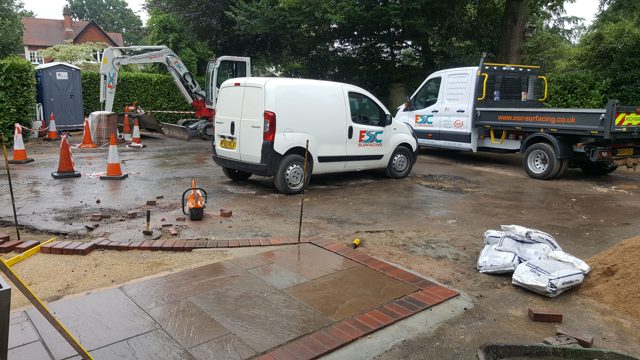 Block paver edging and slab paving during driveway construction