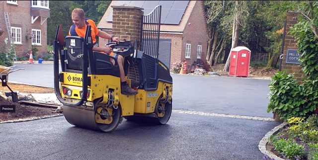 Ride-on roller compacting a curved driveway