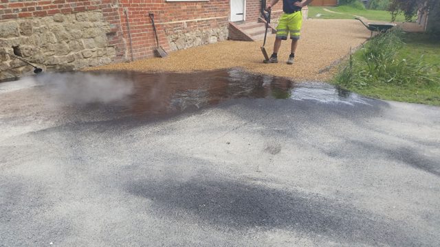 Liquid bitumen binder being applied to a driveway surface