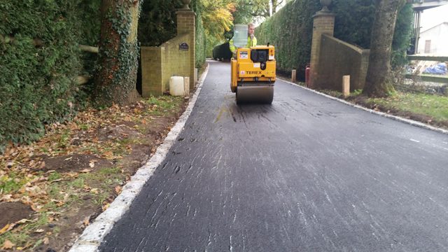 Roller compacting asphalt on a private road