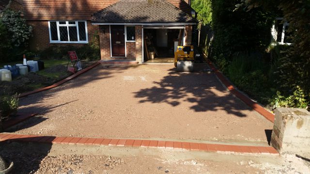 Levelled aggregate base with red brick edging