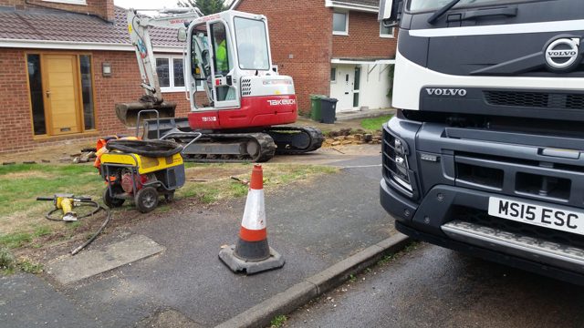 Excavator and tipper at a driveway construction site